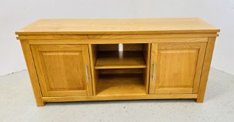 A MODERN LIGHT OAK TELEVISION STAND WITH CUPBOARD AND SHELVED BASE, WIDTH 133CM.