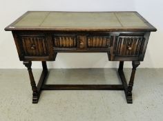 AN OAK WRITING TABLE WITH GREEN AND GILT TOOLED LEATHER TOP WITH THREE FRIEZE DRAWERS WITH