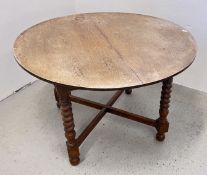 AN OVAL OAK DINING TABLE WITH LEAF ON 'CORKSCREW' TURNED SUPPORTS.