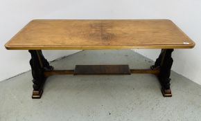 A WALNUT RECTANGULAR COFFEE TABLE ON CARVED FISH SUPPORTS JOINED BY A STRETCHER MOUNTED WITH A