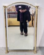 A MID CENTURY STYLE ARCHED WALL MIRROR WITHIN A BRASS FRAME, W 66CM X H 102CM.