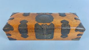 AN ANTIQUE ORIENTAL WOODEN BOX ADORNED WITH DECORATIVE METAL MOUNTS, W 26 X D 9.5 X H 7CM.