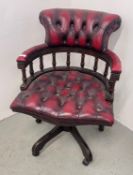 AN OXBLOOD LEATHER REVOLVING CAPTAINS STYLE OFFICE CHAIR WITH BUTTON BACK SEAT - TRADE SALE ONLY.