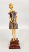 A GIRL IN SHORT OFF THE SHOULDER DRESS STANDING IN DEMURE POSTURE, THE FLESH PARTS IN COMPOSITION,