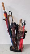 A MODERN CAST METAL STICK STAND WITH ASSORTED UMBRELLAS AND STICKS.