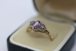 A 9CT GOLD THREE STONE DRESS RING.