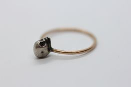 AN ANTIQUE YELLOW AND WHITE METAL MEMENTO MORI SKULL RING.