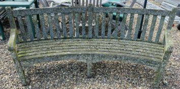 A CURVED HARDWOOD GARDEN BENCH, LENGTH 220CM.