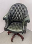 A BOTTLE GREEN LEATHER BUTTON BACK CHESTERFIELD STYLE REVOLVING OFFICE CHAIR - TRADE SALE ONLY.