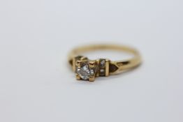 A DIAMOND RING, THE PRINCIPLE BRILLIANT CUT DIAMOND FLANKED BY FOUR SMALL DIAMONDS, STAMPED 850.