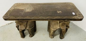 AN EASTERN CARVED HARD WOOD OCCASIONAL TABLE, THE SUPPORTS DEPICTING CARVED ELEPHANTS,