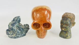 A POLISHED SOAP STONE SKULL, CANADIAN ORIGINAL WOLF SCULPTURE AND AN AFRICAN CARVED STONE HEAD.