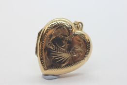 A 9CT GOLD ENGRAVED HEART SHAPED LOCKET.