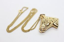 A 9CT GOLD CHARM IN THE FORM OF A HORSES HEAD SUPPORTED BY AN UNMARKED YELLOW METAL CHAIN, L 36.5CM.