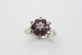 AN 18CT WHITE GOLD DIAMOND AND AMETHYST SET FLOWER HEAD RING.