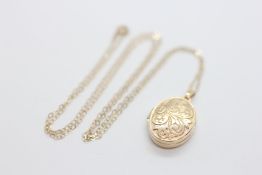 AN ENGRAVED 9CT GOLD OVAL PHOTO LOCKET SUSPENDED ON A FINE 9CT GOLD CHAIN, L 45CM.