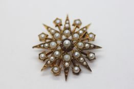 A 9CT YELLOW GOLD PIN BROOCH OF STAR DESIGN SET WITH GRADUATED SEED PEARLS.