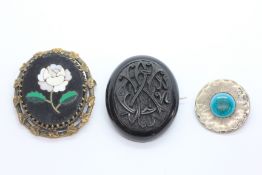 THREE ANTIQUE BROOCHES TO INCLUDE ART AND CRAFTS GILD BUTTON BY NORMAN AND ERNEST SPITTLE AND