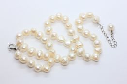 A SINGLE STRAND OF NEAR UNIFORM FRESHWATER PEARLS WITH SILVER CLASP AND A PENDANT PEARL,