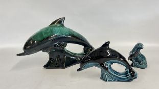 A POOLE POTTERY DOLPHIN AND OTHER ALONG WITH A SIMILAR GLAZED DOLPHIN.