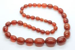 A STRAND OF AMBER / BAKELITE TYPE BEADS.