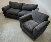 A CHARCOAL GREY TWO PIECE LOUNGE SUITE COMPRISING OF A LARGE THREE SEATER SOFA AND A SINGLE CHAIR.