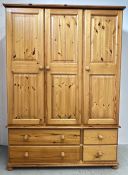 A GOOD QUALITY SOLID PINE TRIPLE WARDROBE WITH FOUR DRAWER BASE.