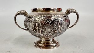 AN EMBOSSED INDIAN WHITE METAL TWO HANDLED POT.