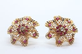 A PAIR OF VINTAGE DENTELLE SCREW ON EARRINGS MARKED 14K SET WITH RUBIES AND A CENTRAL BRILLIANT CUT