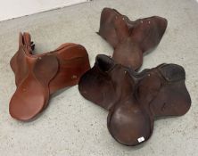 THREE VINTAGE LEATHER SADDLES.