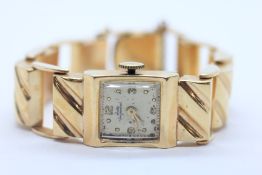 A LADIES JULES JURGENSEN VINTAGE 14CT GOLD CASED WRIST WATCH ON 14CT GOLD BRACELET (THE GLASS FACE