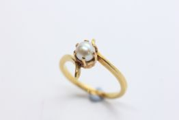AN UNMARKED CONTEMPORARY DESIGN YELLOW METAL DRESS RING SET WITH SOLITAIRE PEARL IN CLAW SETTING.