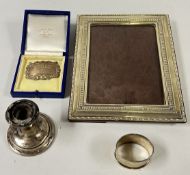 A SILVER PHOTOGRAPH FRAME ALONG WITH A SMALL SILVER SQUAT CANDLESTICK A/F AND A SILVER DECANTER