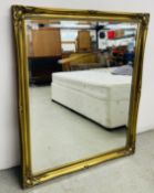 AN IMPRESSIVE MODERN GILT FRAMED WALL MIRROR WITH BEVELLED PLATE GLASS, OVERALL SIZE 130CM X 106CM.