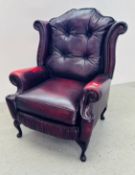 A MODERN OXBLOOD LEATHER BUTTON BACK WINGED ARMCHAIR.