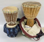 TWO TRADITIONAL WEST AFRICAN DJEMBE DRUMS IN HAND CRAFTED PROTECTIVE MATERIAL BAGS (1 A/F SMALL