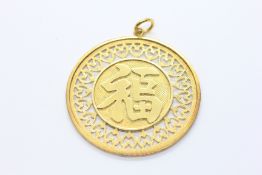 A CIRCULAR DISC PENDANT WITH PIERCED DECORATION, THE CENTRE WITH CHINESE TEXT, MARKED 14K,