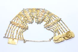 AN UNMARKED YELLOW METAL MULTI STRAND BRACELET THE 8 STRANDS INTER DISPERSED WITH PANELS HAVING