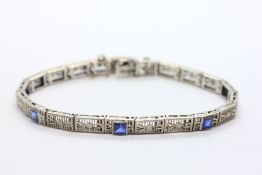 A DECO FILIGREE PANEL BRACELET SET WITH THREE SQUARE CUT SAPPHIRES, THE CLASP MARKED 14K.