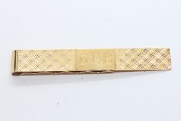 A 14CT YELLOW GOLD TIE SLIDE MARKED 14K, CHEQUERED ENGRAVING AND ENGRAVED WITH THE INITIALS G.C.B.