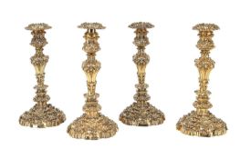 AN IMPRESSIVE SET OF FOUR LATE GEORGE III ENGLISH SILVER GILT CANDLESTICKS