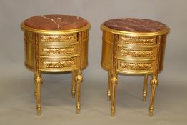 A PAIR OF GILTWOOD OVAL SHAPED THREE DRAWER BEDSIDE TABLES, with rouge marble tops. 2ft 3ins high