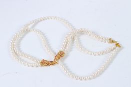 A TWO ROW PEARL, SILVER, GOLD PLATED RUBY AND EMERALD PANTHER NECKLACE.