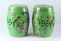 A PAIR OF CHINESE STYLE PORCELAIN BARREL SEATS, green ground, decorated with birds and flowers.