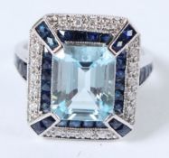 A 9CT SAPPHIRE, DIAMOND AND EMERALD CUT BLUE TOPAZ DECO RING.
