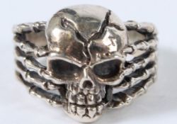 A SILVER SKULL HEAD RING.