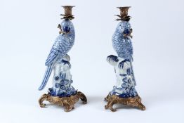 A PAIR OF BLUE AND WHITE PORCELAIN PARROT CANDLESTICKS, with ormolu mounts. 36cms high.