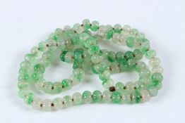 A STRING OF PUMPKIN JADE BEADS.