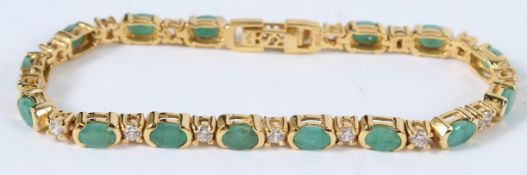 A SILVER AND 18CT GOLD PLATED EMERALD AND CZ TENNIS BRACELET.