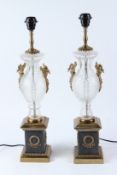 A PAIR OF GLASS URN SHAPED TABLE LAMPS, on ornate metal bases. 62cms high.